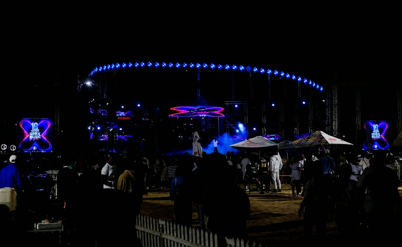 Alex Music Festival main stage at night with blue stage lights and crowd